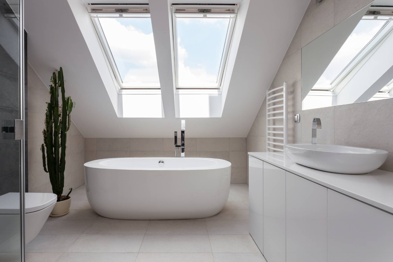 A white freestanding bathtub with skylights in a modern bathroom with cactus decor at PSI Window Coverings near Scottsdale, AZ