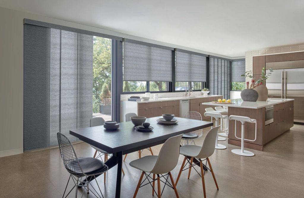  Large kitchen and dining room with many windows all decorated with Hunter Douglas Designer Roller Shades at PSI Window Coverings near Scottsdale, AZ